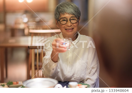 旅館の夕食でシニア夫婦がお酌を交わす温かいひととき 旅館の夕食でシニア夫婦がお酌を交わす温かいひととき 133948604