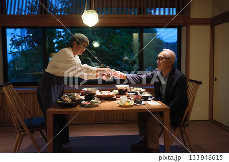 旅館の夕食でシニア夫婦がお酌を交わす温かいひととき 133948615