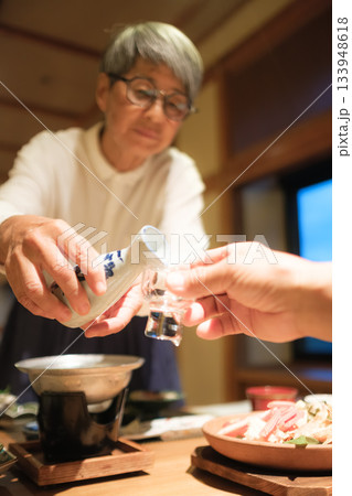 旅館の夕食でシニア夫婦がお酌を交わす温かいひととき 旅館の夕食でシニア夫婦がお酌を交わす温かいひととき 133948618