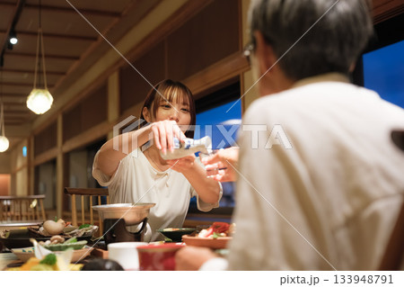 母娘で迎える還暦祝いの旅。旅館の静かな夕食で、温かな時間を分かち合う二人 133948791