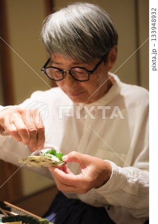 シニア夫婦が還暦祝いの旅行で旅館の会席料理をゆったり味わう夕食シーン シニア夫婦が還暦祝いの旅行で旅館の会席料理をゆったり味わう夕食シーン 133948932