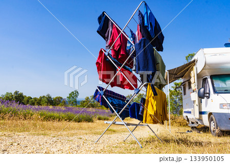 Clothes hanging to dry outdoors by camping car. Caravan vacation. 133950105
