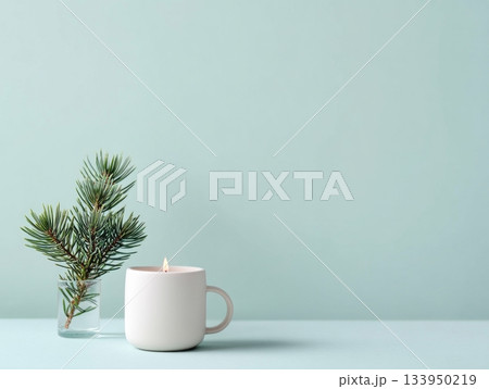 White cup, candle and pine sprig on pastel mint background White cup, candle and pine sprig on pastel mint background 133950219