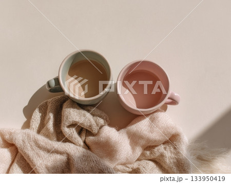 Two ceramic cups with wool scarf cozy scene 133950419