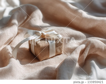 Small gift box on beige fabric 133950421