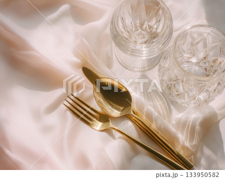 Elegant festive composition with crystal glasses and golden cutlery 133950582