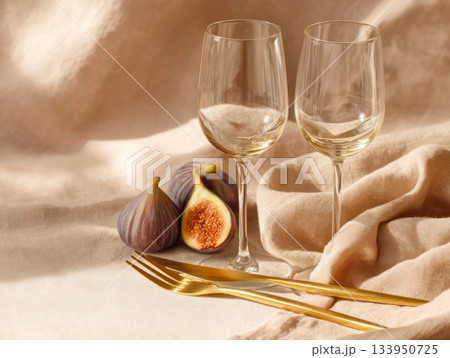 Wine glasses and figs on beige fabric 133950725