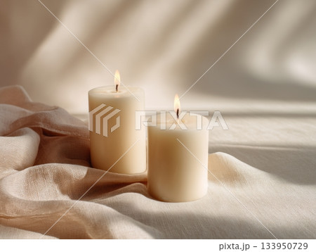 Two lit candles on linen soft minimal setup Two lit candles on linen soft minimal setup 133950729