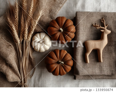Autumn flatlay with pumpkins, dried wheat and wooden deer on linen fabric 133950874