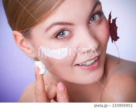 Skin care. Face of young woman girl with red maple leaf. Skin care. Face of young woman girl with red maple leaf. 133950951