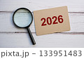 Magnifying Glass Focusing on Red 2026 Text on Cardboard Paper for Future Planning or Forecast Concept 133951483