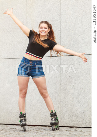 Young woman riding roller skates Young woman riding roller skates 133951647
