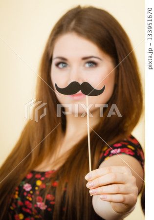 Happy woman holding fake moustache on stick 133951670