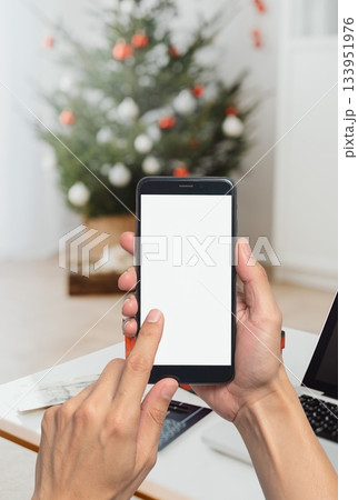 Person using smartphone for online shopping during christmas holiday, browsing in e commerce app ,on mobile phone for gifts, enjoying convenient digital purchase experience 133951976