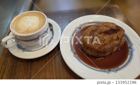 Delicious torrija dessert served with coffee in a cozy cafe setting. Traditional spanish dessert for Lent and Holy Week. French toast with wine Delicious torrija dessert served with coffee in a cozy cafe setting. Traditional spanish dessert for Lent and Holy Week. French toast with wine 133952196