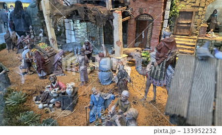 Traditional Christmas nativity scene with figurines and miniature village display 133952232