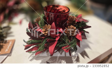 Christmas candle centerpiece with pine cones and red leaves for holiday decor. Merry Christmas Christmas candle centerpiece with pine cones and red leaves for holiday decor. Merry Christmas 133952852