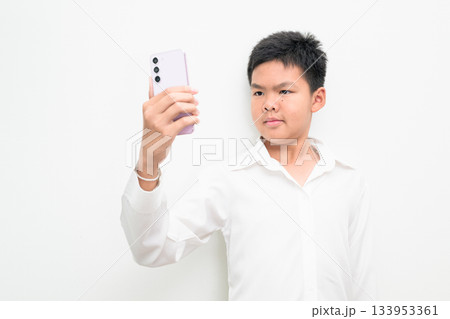 Asian Teenage Boy Student Studio Portrait on White Background Using Mobile Phone Asian Teenage Boy Student Studio Portrait on White Background Using Mobile Phone 133953361