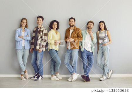 Group of young friends standing together isolated on gray background and looking at camera. 133953638