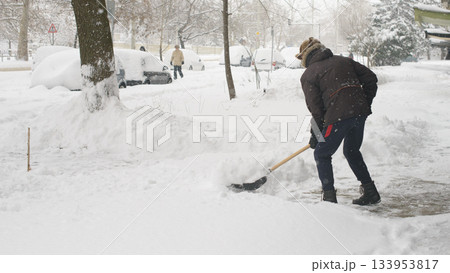 Worker Clears Deep Snow From Outdoor Walkway In Winter 133953817