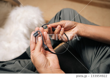Person holding modern bone-conduction headphones with both hands, showcasing innovative audio technology designed for open-ear listening and awareness of surroundings during various activities. Person holding modern bone-conduction headphones with both hands, showcasing innovative audio technology designed for open-ear listening and awareness of surroundings during various activities. 133954922