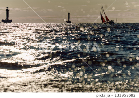Sailing regatta in the Gulf of Finland at sunset, sailing yacht competing in a race, splashing water from under the boat, teamwork, board the boat Sailing regatta in the Gulf of Finland at sunset, sailing yacht competing in a race, splashing water from under the boat, teamwork, board the boat 133955092