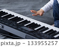 Kid wants to touch keys of piano with his finger. Closeup. 133955257