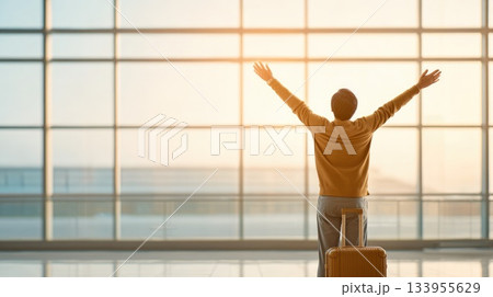 Traveler Celebrating Arrival in Airport Terminal Traveler Celebrating Arrival in Airport Terminal 133955629