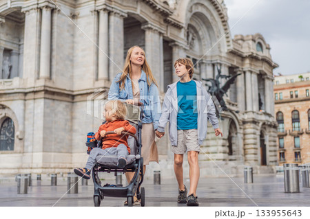 Mother tourist with her two sons in front of Palacio de Bellas Artes in Mexico City, enjoying family travel, architecture, and cultural heritage. Family travel and bonding concept 133955643