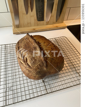 Sourdough bread with golden brown crust and rustic texture, sliced to reveal soft airy crumb inside, highlighting its natural shape, crisp surface, and artisanal detail in close-up view Sourdough bread with golden brown crust and rustic texture, sliced to reveal soft airy crumb inside, highlighting its natural shape, crisp surface, and artisanal detail in close-up view 133956301