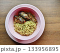 Instant noodles with spicy canned fish in a pink bowl, simple budget meal. 133956895