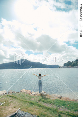 海辺で腕を広げる女性 133956903