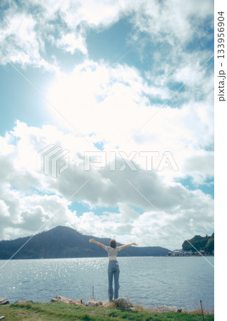 海辺で腕を広げる女性 133956904