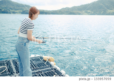 海辺で釣りを楽しむ女性 133957059