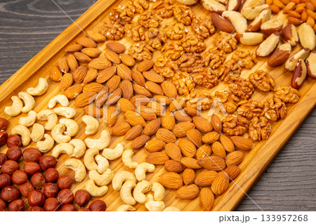 assorted nuts on a kitchen wooden board. vitamin vegetarian food 133957268
