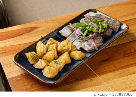 Seared fish dinner, Homestyle dish featuring seared tuna and herb roasted potatoes on dark ware 133957360