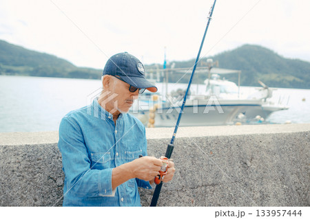 釣り竿を眺めるシニア男性 133957444