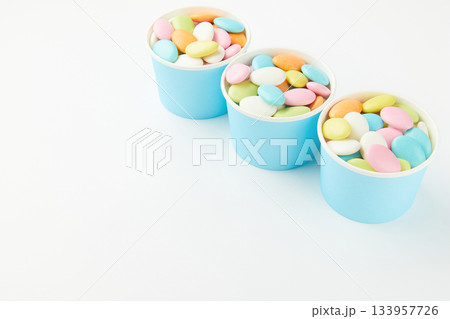 Traditional Easter Portuguese candies. Colorful Sweets in a blue paper cups on a white background 133957726