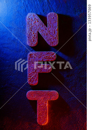 NFT Letters Illuminated by Neon Lighting on Textured Surface 133957869