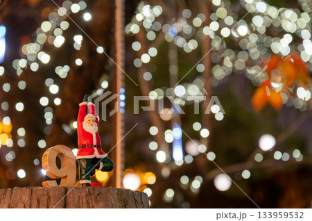 ヨガポーズのサンタ人形とイルミネーションのボケが広がるクリスマス風景 133959532