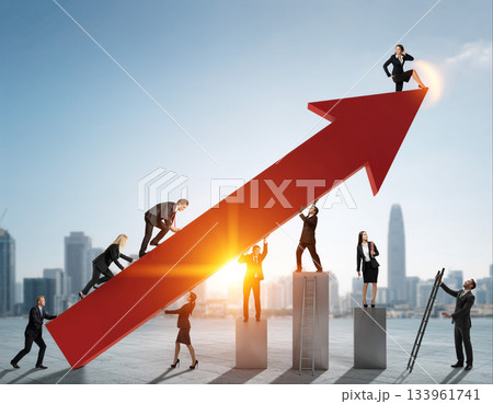 Business team working together to achieve success and growth on a large upward arrow in a city setting 133961741