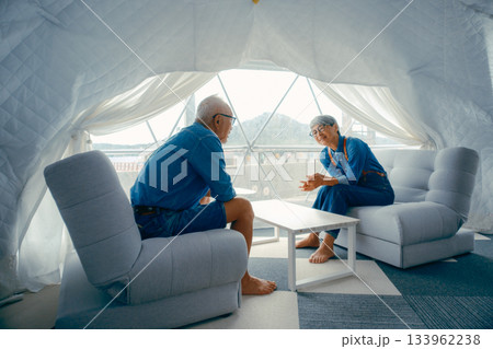 グランピング施設でくつろぐシニア夫婦の会話シーン 133962238
