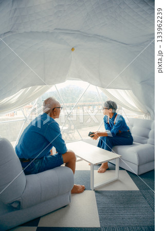 グランピング施設でくつろぐシニア夫婦の会話シーン 133962239