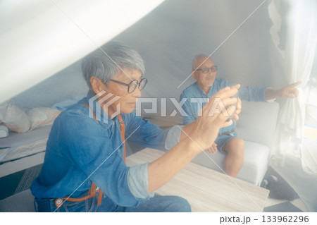 グランピング施設でスマホ撮影を楽しむシニア夫婦 グランピング施設でスマホ撮影を楽しむシニア夫婦 133962296