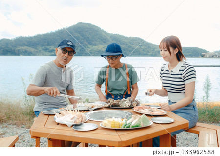湖畔で親子3人がBBQを楽しむシーン 133962588