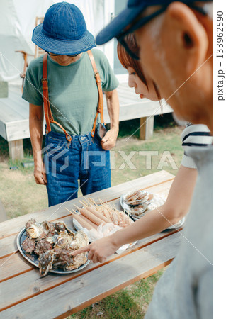 湖畔で親子3人がBBQを楽しむシーン 133962590