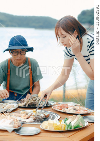 湖畔で親子3人がBBQを楽しむシーン 湖畔で親子3人がBBQを楽しむシーン 133962591