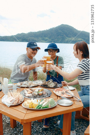 海辺で親子三人の乾杯シーン 133962735