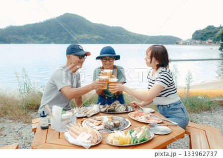 海辺で親子三人の乾杯シーン 133962737