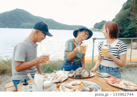 海辺で親子三人の乾杯シーン 133962744